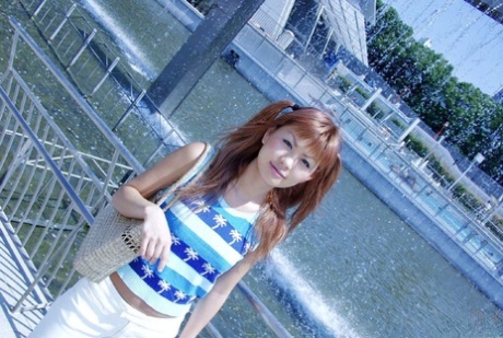 Cute Japanese redhead Aki gets naked while sporting pigtails