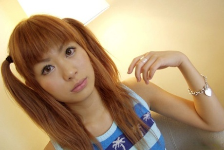 Cute Japanese redhead Aki gets naked while sporting pigtails