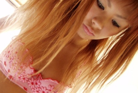 Cute Japanese redhead Aki gets naked while sporting pigtails