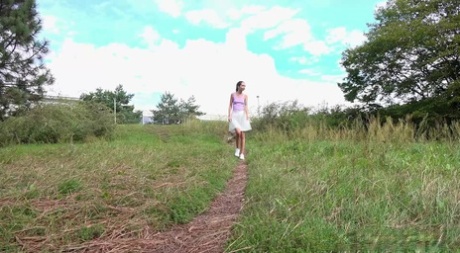 Thin girl Mistika takes a piss on a path while walking through the countryside
