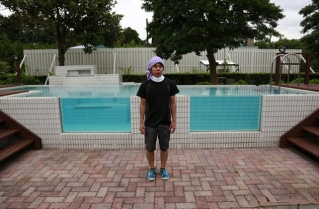 A bunch of Japanese beauties pose in the nude in front of a swimming pool