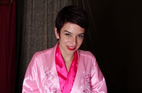 Short haired mature woman Nikki Lee removes lingerie in bedroom