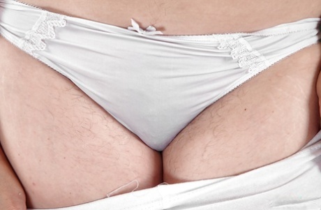 Older woman Mel Harper slips out of spandex pants and panties to expose beaver