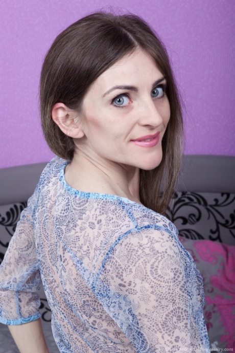 Skinny blue-eyed brunette Olivia Arden peels on her bed to flaunt hairy pussy