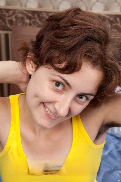 Horny chick Alisa reveals her tiny breasts and hairy muff on a bed