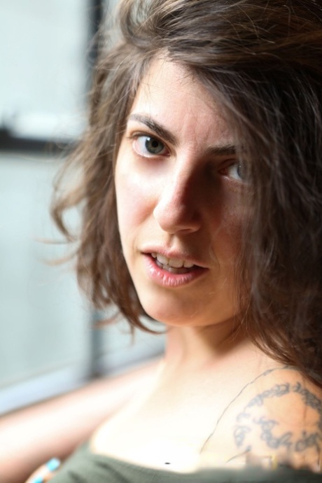 Big boobed amateur brunette Nora getting naked and revealing her bushy beaver