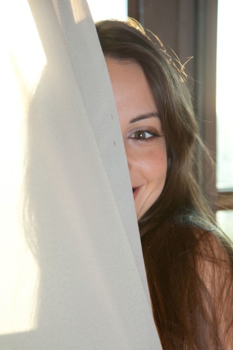 Beautiful brunette teen Lorena B unveils her hairy pussy and poses in a solo