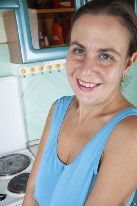 Cute mature housewife Beatrice A plays with her fuzzy pussy in the kitchen