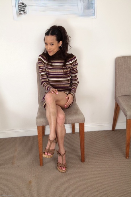 Exotic Asian teen Ayla Skye playing with her long pussy hair on a chair